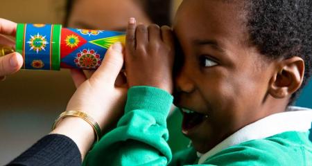 A child looking into a kaleidoscope
