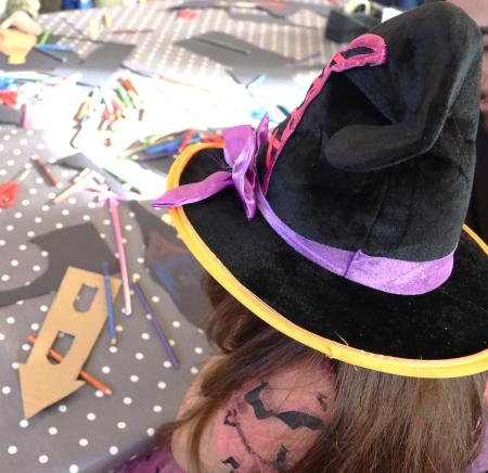 Young girl in black hat doing craft workshop