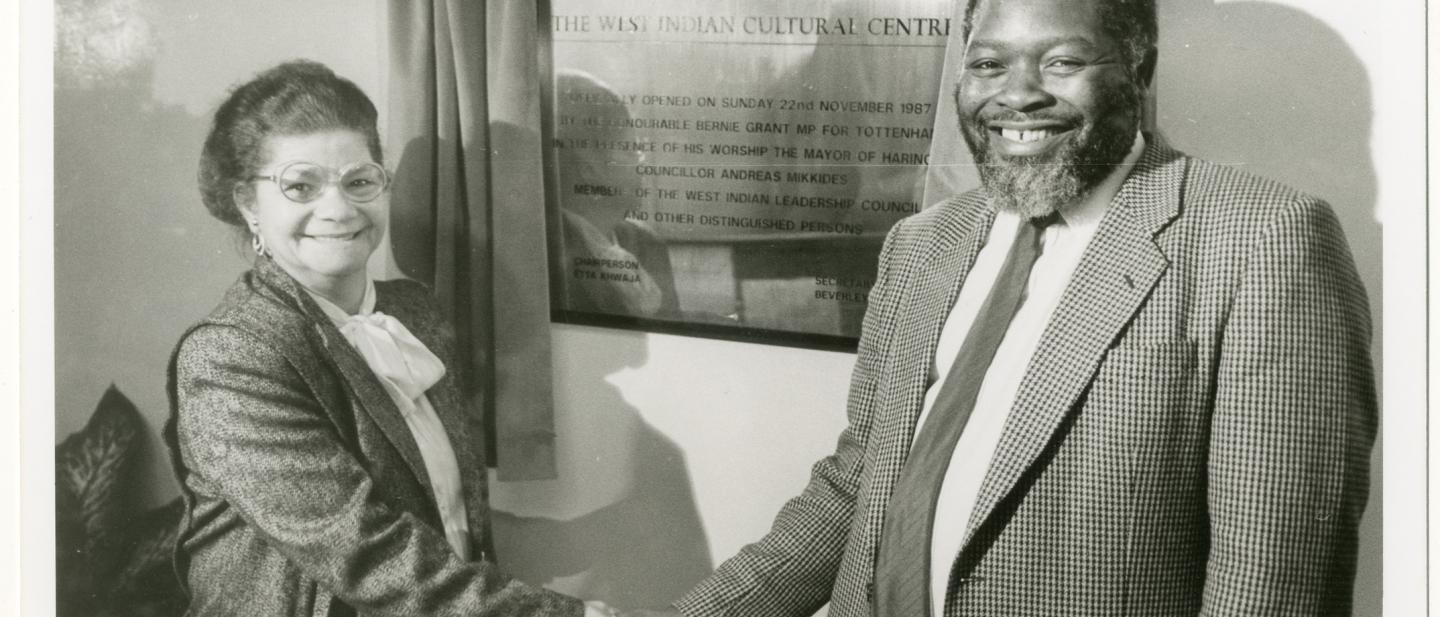 Bernie Grant and woman shaking hands with the opening plaque for the West Indian Cultural Centre in the background