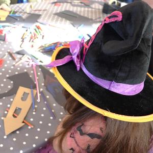 Young girl in black hat doing craft workshop
